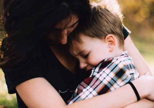 boy cuddling with mother