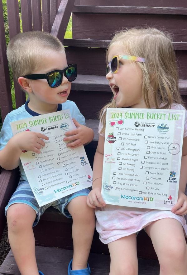 two kids in sunglasses holding summer bucket list printable