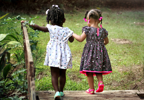 two girls holding hands walking up steps