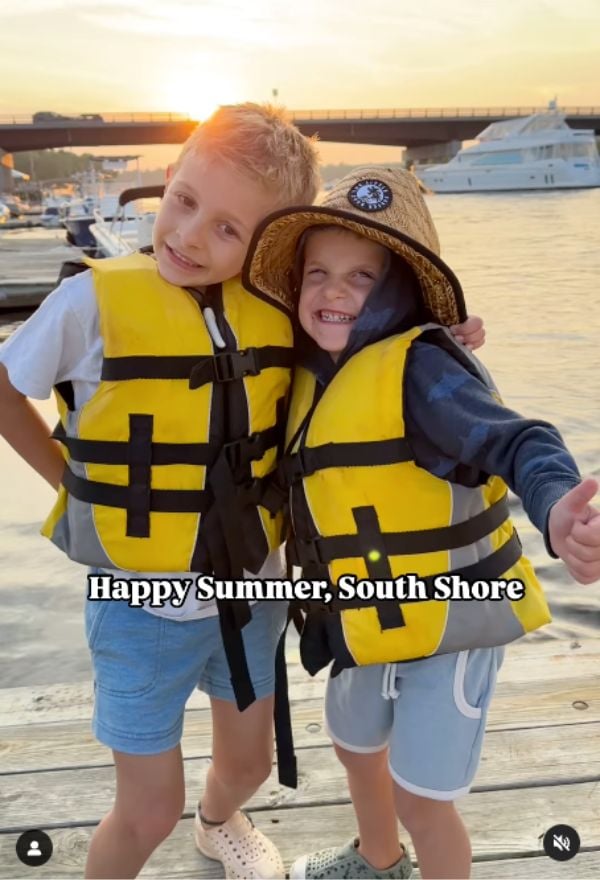 two boys in life vests with their arms around each other