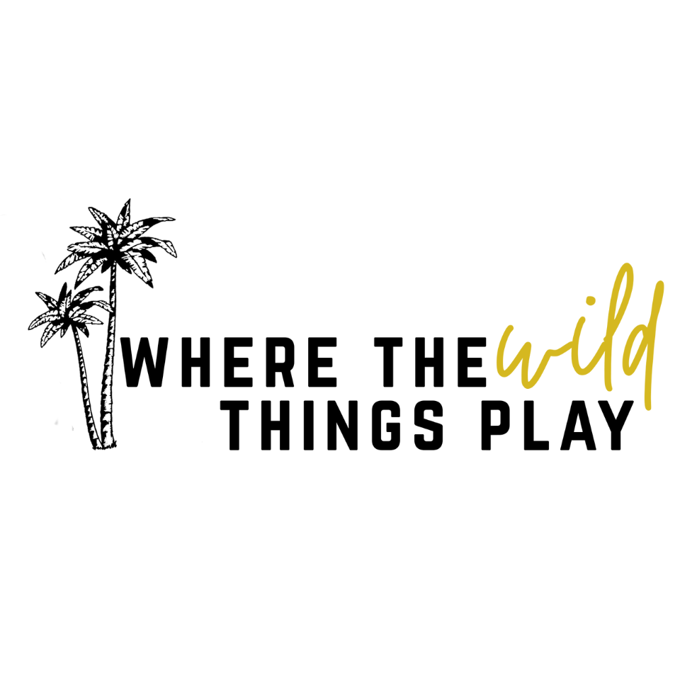 Where The Wild Things Play Logo with black block font, the word wild is gold in cursive font, with two palm trees on the side of the logo