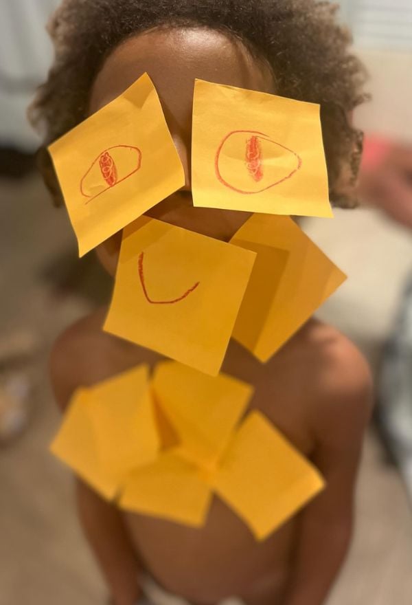 kid with sticky notes on face