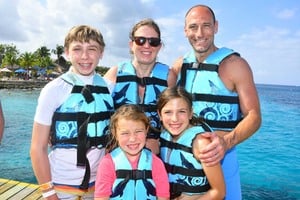 Young family on vacation wearing life jackets.