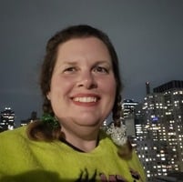 Woman smiling with a city-scape behind her