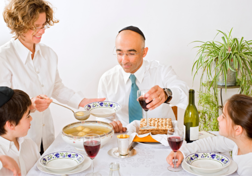 Mother, father and two children at a table eating a Passover meal