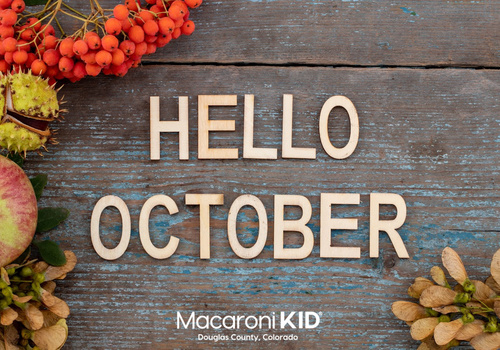 fall items on a wooden table with text that says hello october and macaroni kid logo