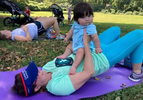Mom doing yoga and holding baby