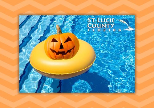 Jack-o-lantern on top of a yellow float in a pool