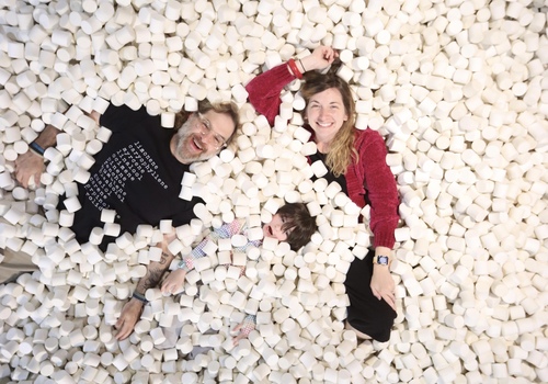 Woman, man, and child in marshmallow pit
