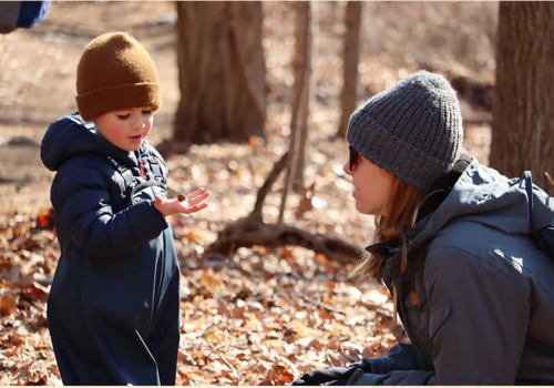 child with caregiver in fall forest