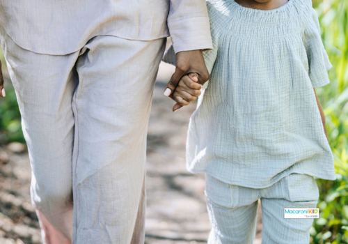 adult holding hands and walking with a child
