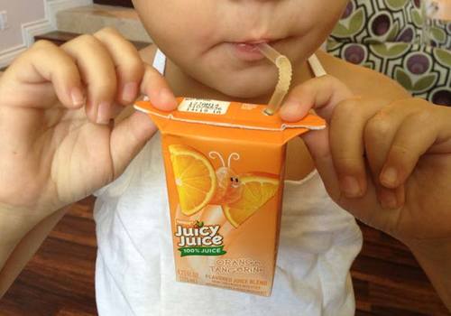 Kid holding a juice box by the handles