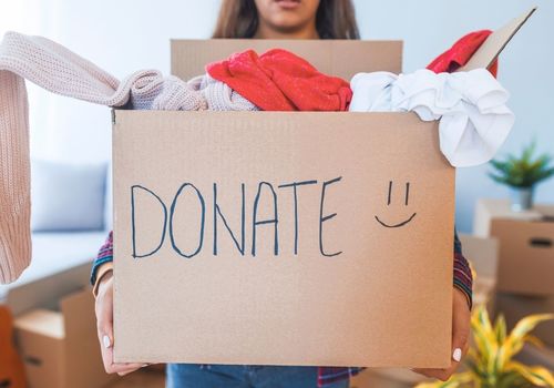 Woman holding box of clothes for donation