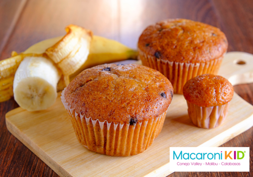 bananas chocolate chip muffins on a wood cutting board with an open banana