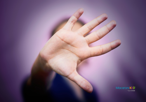 hand held out with purple background (signifying domestic violence awareness)