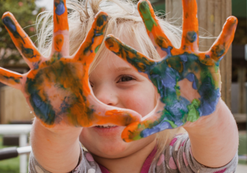 Child's hands all messy with paint