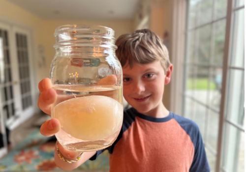 boy holding out egg in vinegar