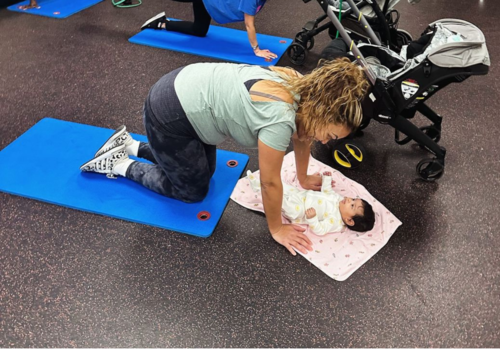 Mom looking at her baby while she exercises