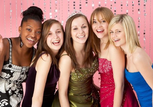 5 smiling teenage girls in formal prom dresses