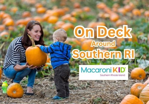 Mother and child in pumpkin patch, mother holidng and showing child pumpkin