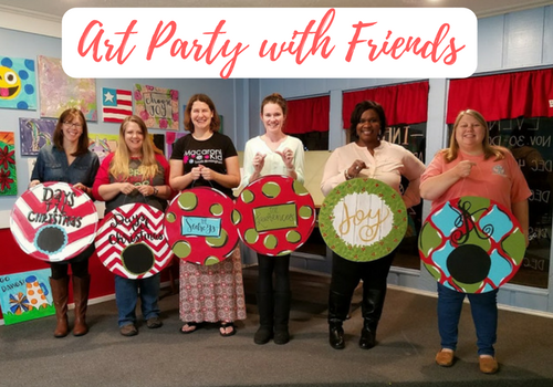 Group of women pose with completed art party projects