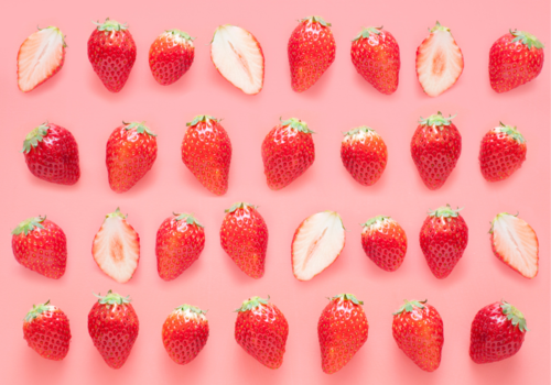 mutliple strawberries on pink background