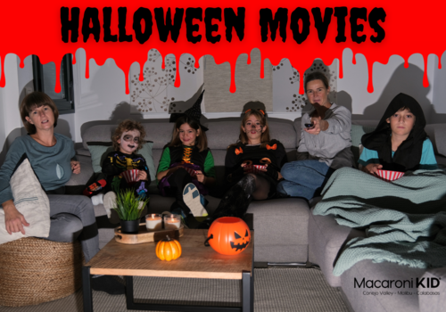 Halloween Movies, family in costume sitting on a sofa in a dim lit room watching a show