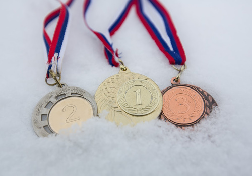 1st, 2nd, and 3rd place medals lying on top of snow