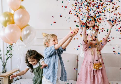 kids at a party with confetti and balloons