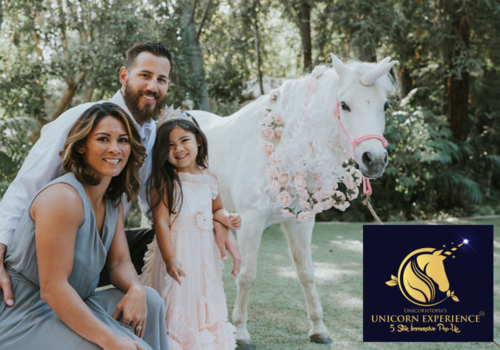 Parents and daughter in a magical garden with a unicorn