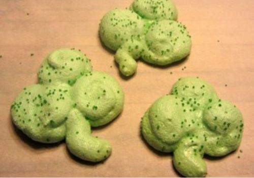 Three Lime Shamrock Meringue Cookies, green with green sugar sprinkles.