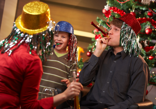 Family with party hats and noise makers. How to celebrate New Year's at home.