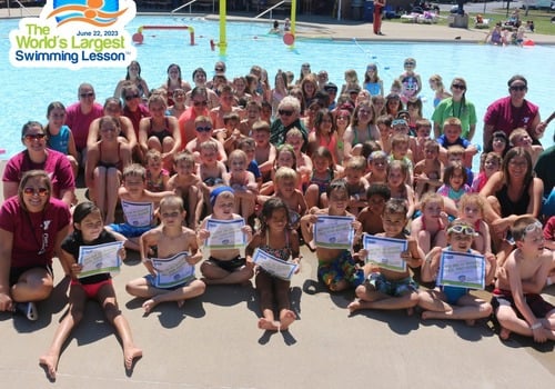 50 plus kids holding certificates at pool