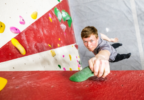 Teen hanging from a rock wall