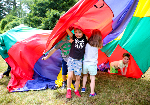 Children play with parachute at Cranbrook Schools Summer Camps Brookside Tots