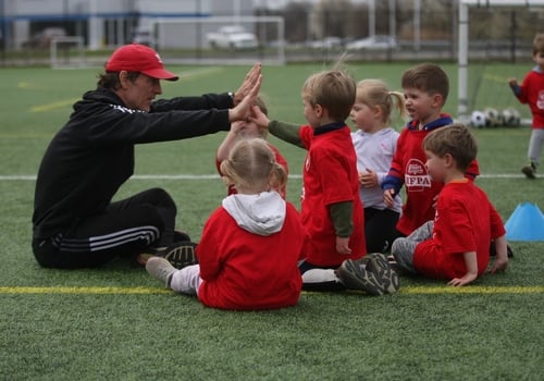 Penn Fusion Soccer Camp coach and players on field