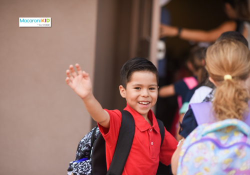 kid waving as he heads into school