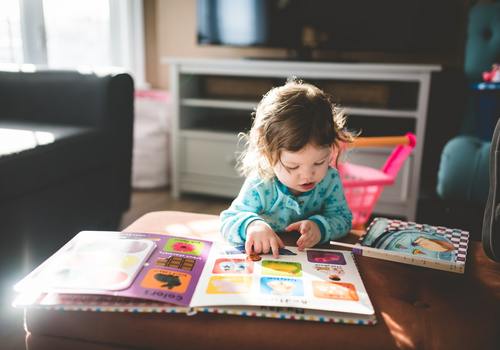 Little girl reading a picture book