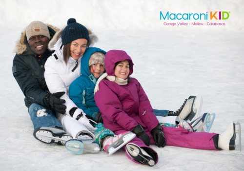Family of four wearing skates sitting on the Ice