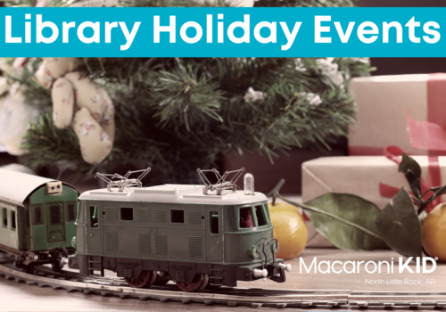 model train on a track with a christmas tree and presents in the background