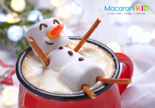 Marshmallow snowman floating in a cup of hot cocoa