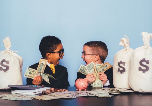 Allowances and Kids: How to Build Good Spending Habits Early. Kids holding money and smiling