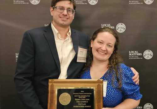 Photo of two Oconee Enterprise staff members holding award