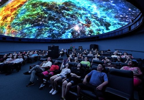 Audience viewing a galaxy in a planetarium