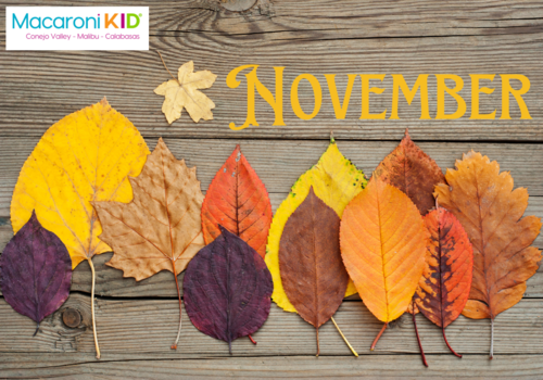 November against wood planks with a variety of fall leaves of varying colors and shapes