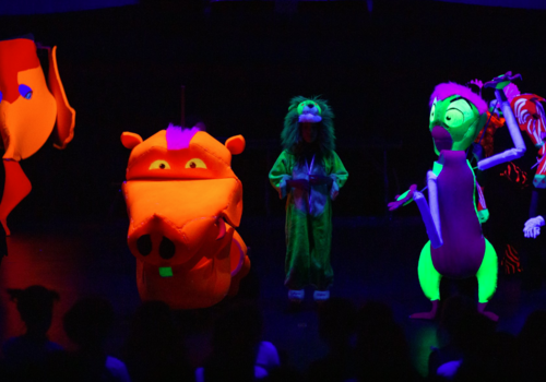 Kids performing in a black light show