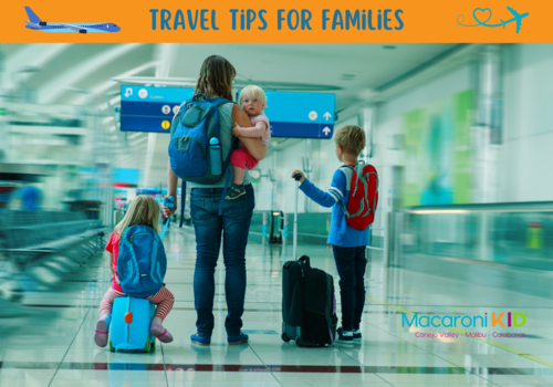 Travel Tips for Families, a mom wearing a back pack holding a young child while pulling a slightly older child sitting on a suitcase with an older child pulling  a rolling suitcase