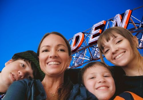 two women and two younger boys smiling in front of Ogden sign family kids things to do events happenings local deals discounts fun attractions ideas places to go what going on around near me