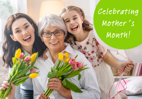 mom, grandma and daughter smiling and holding flowers