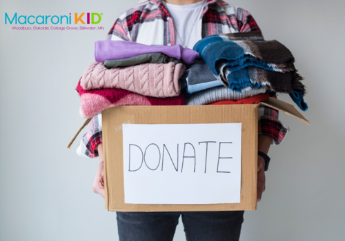 Person holding box of clothes with a sign of donate on the box